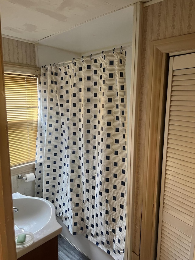 bathroom featuring wallpapered walls and vanity