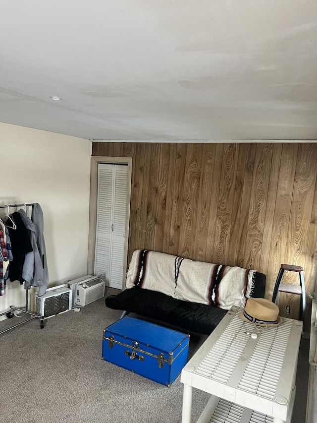 living area featuring wooden walls and carpet flooring