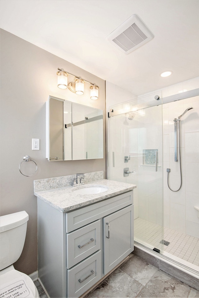 bathroom with visible vents, toilet, a stall shower, and vanity