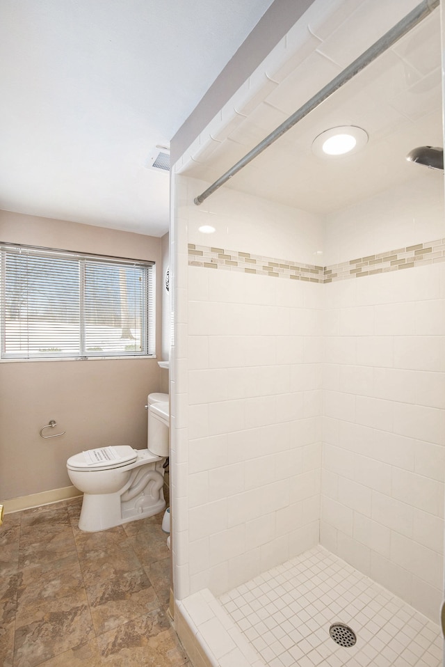 bathroom with visible vents, a shower stall, toilet, and baseboards