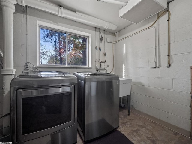 laundry area featuring laundry area, washing machine and dryer, and concrete block wall