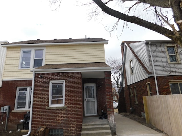 back of house with fence and brick siding