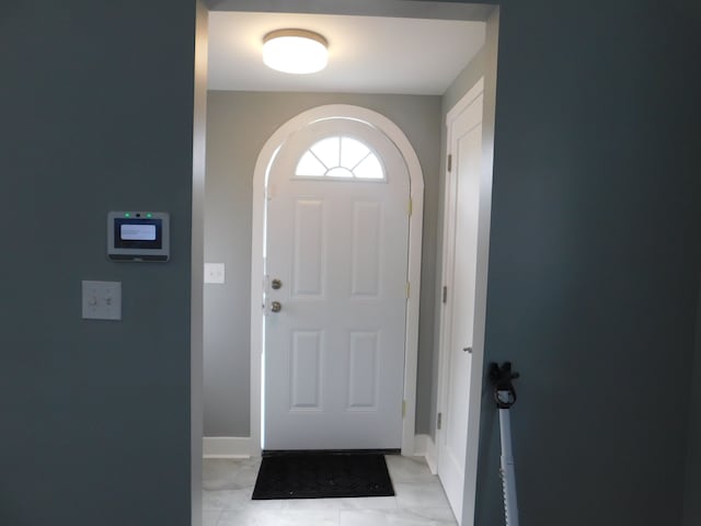 doorway featuring arched walkways and baseboards