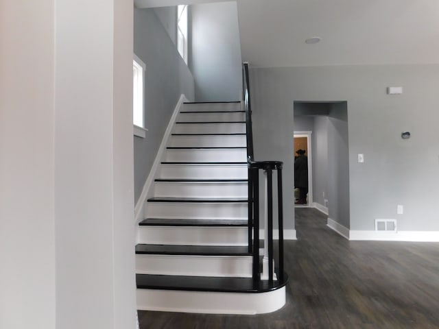 stairs with visible vents, baseboards, and wood finished floors