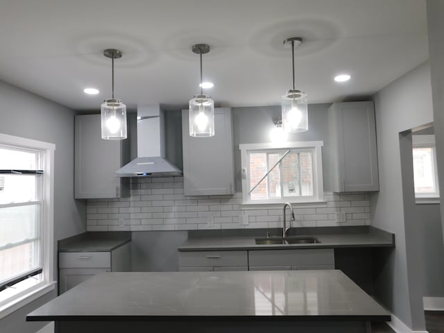 18978 Prairie St, Detroit, MI 48221 - kitchen featuring tasteful backsplash, a kitchen island, wall chimney range hood, hanging light fixtures, and a sink