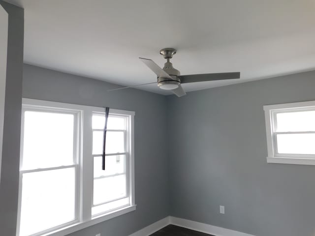 spare room with baseboards and ceiling fan