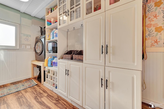 laundry room with visible vents, washer / dryer, wainscoting, wood finished floors, and cabinet space