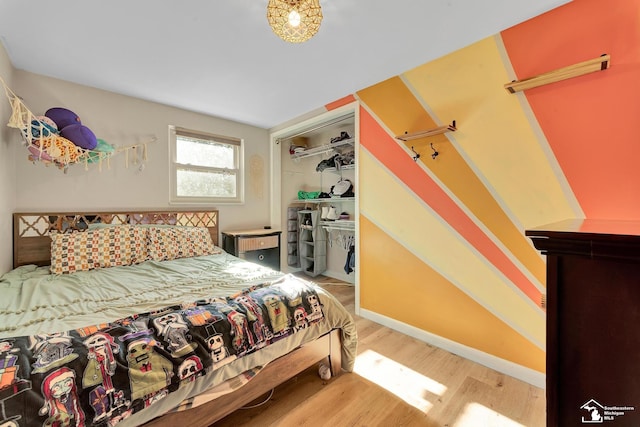 bedroom featuring a closet, baseboards, and wood finished floors