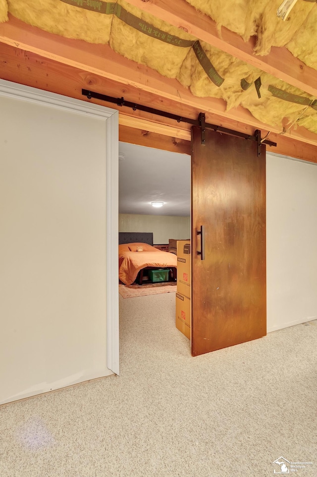 interior space featuring a barn door and carpet floors