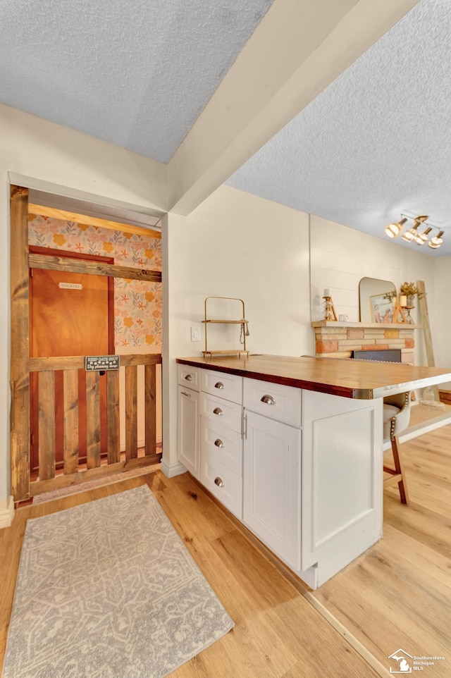 bathroom featuring a textured ceiling and wood finished floors