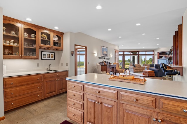 kitchen with recessed lighting, brown cabinetry, light wood-style floors, and a sink