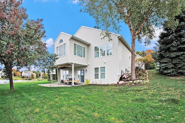 back of house with a yard and a patio