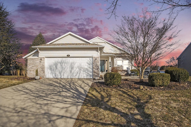 view of front facade featuring stone siding, driveway, and an attached garage