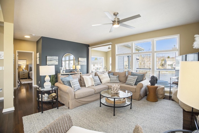 living room with baseboards, wood finished floors, and a ceiling fan