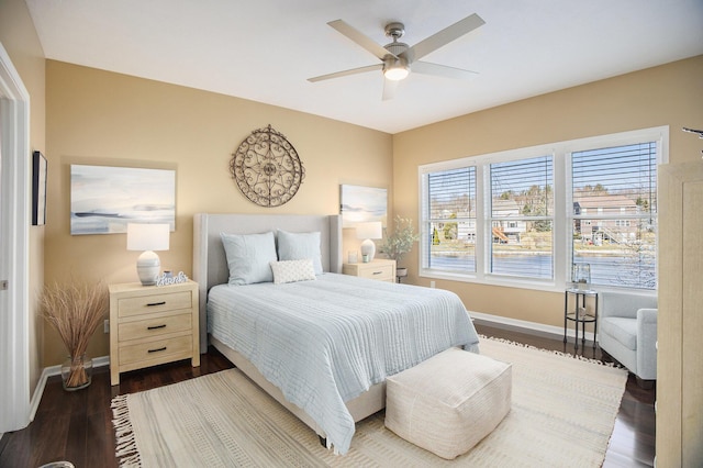 bedroom with a ceiling fan, dark wood-type flooring, and baseboards