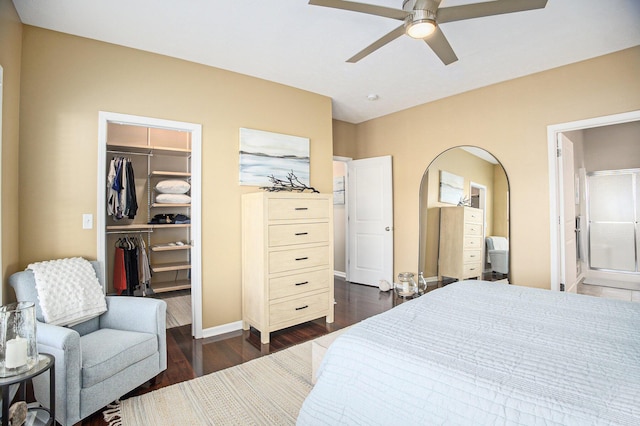 bedroom with a ceiling fan, dark wood finished floors, a closet, baseboards, and a spacious closet