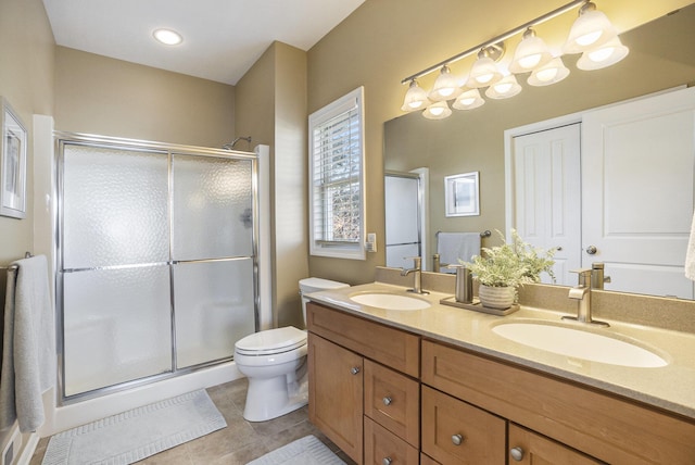 full bathroom featuring tile patterned floors, a shower stall, double vanity, and a sink