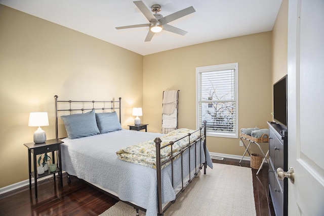 bedroom with ceiling fan, baseboards, and wood finished floors