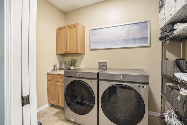 laundry area featuring baseboards, cabinet space, washing machine and dryer, and light tile patterned flooring