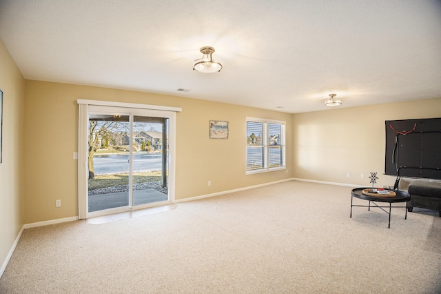 unfurnished room featuring a wealth of natural light, baseboards, and carpet floors