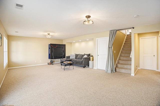 sitting room with visible vents, baseboards, light colored carpet, and stairway