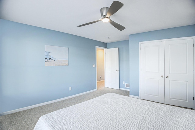 carpeted bedroom featuring a closet, baseboards, and ceiling fan