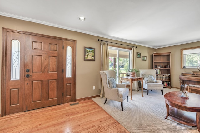 entryway with visible vents, light wood-style floors, and ornamental molding