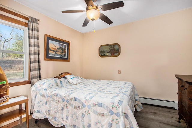 bedroom with a baseboard heating unit, wood finished floors, and ceiling fan