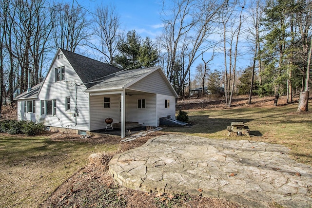 view of home's exterior featuring a lawn and roof with shingles