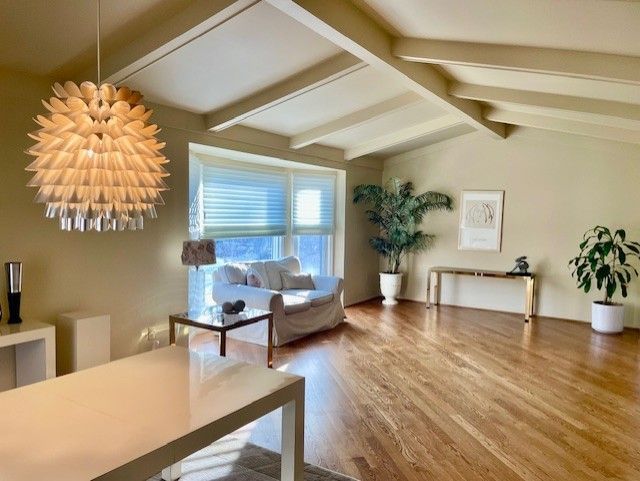 living room with vaulted ceiling with beams and wood finished floors