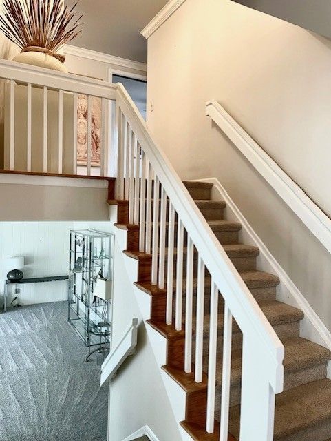 stairway featuring carpet flooring, baseboards, and ornamental molding