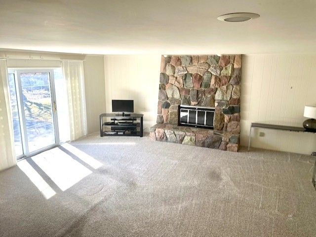 unfurnished living room featuring a fireplace and carpet