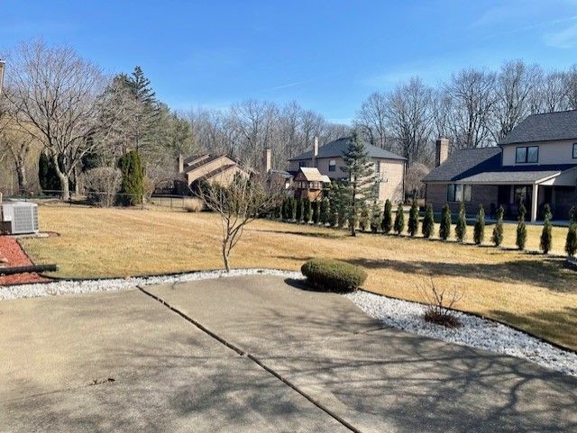 view of yard with central AC unit and fence