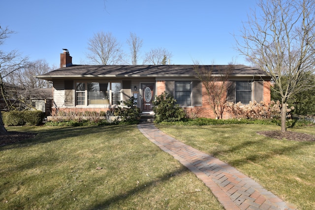 ranch-style house with brick siding, a chimney, covered porch, and a front yard