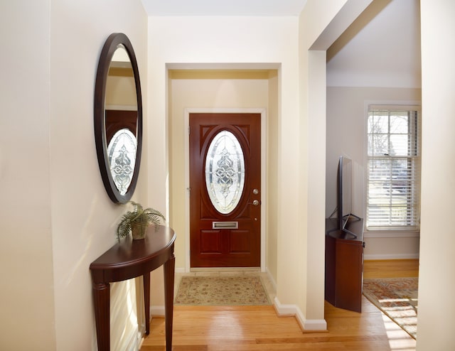 foyer with light wood-style floors and baseboards