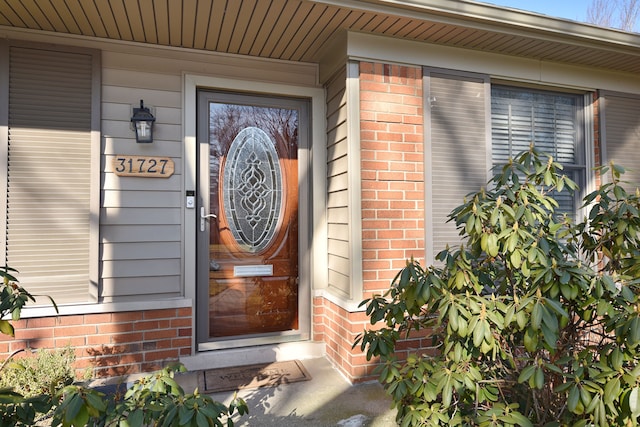 property entrance featuring brick siding