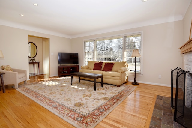 living area featuring recessed lighting, baseboards, wood finished floors, and a tile fireplace