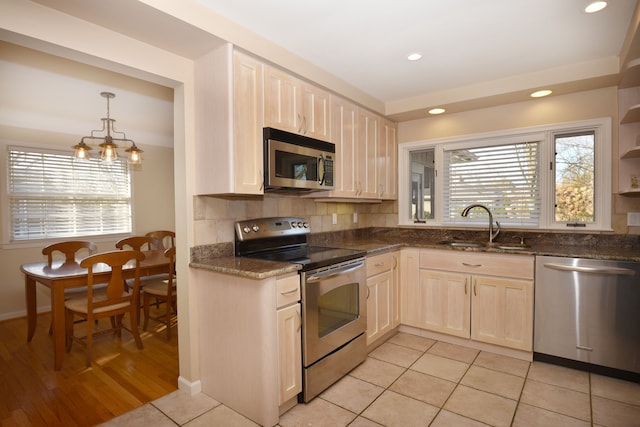 kitchen with a sink, stainless steel appliances, plenty of natural light, and decorative backsplash