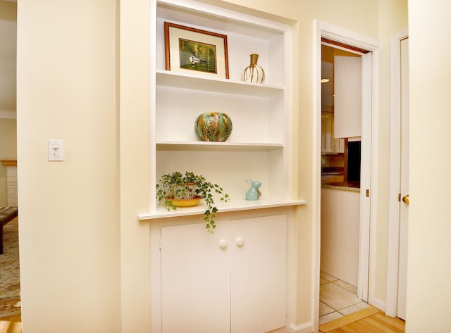 corridor with built in features and light tile patterned floors