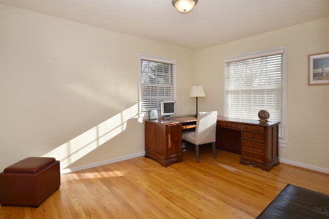 office space featuring baseboards and light wood-style floors