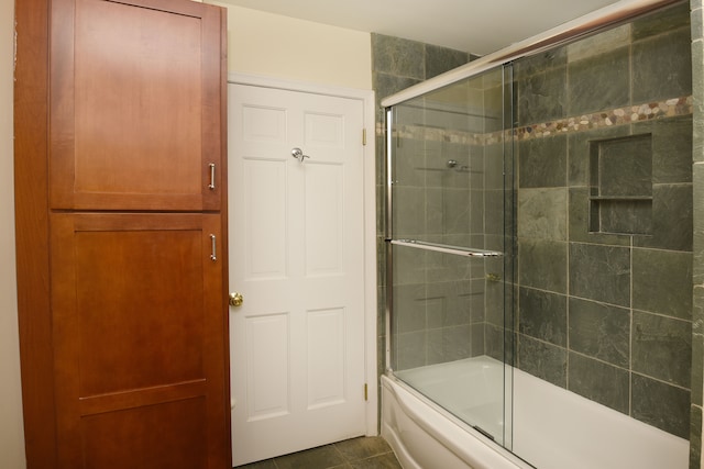 full bath featuring tile patterned flooring and bath / shower combo with glass door