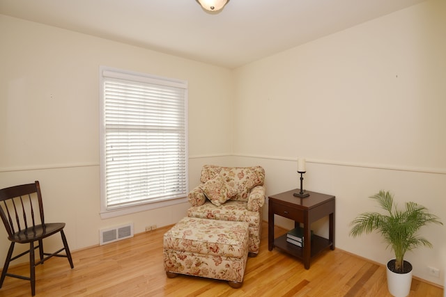 living area with wood finished floors and visible vents