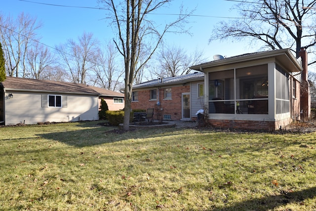 back of property featuring a yard, a chimney, and a sunroom