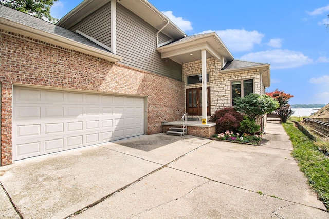 view of front of house with stone siding, brick siding, and concrete driveway