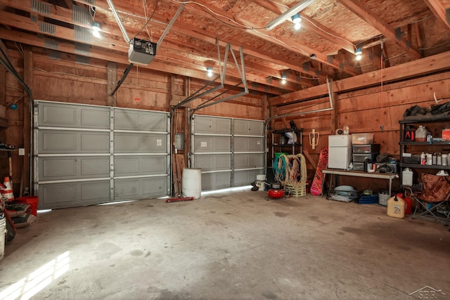 garage with freestanding refrigerator and a garage door opener