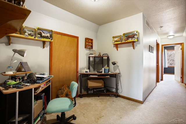 carpeted home office featuring visible vents, a textured ceiling, and baseboards