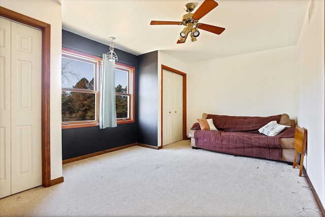 carpeted living room featuring ceiling fan and baseboards