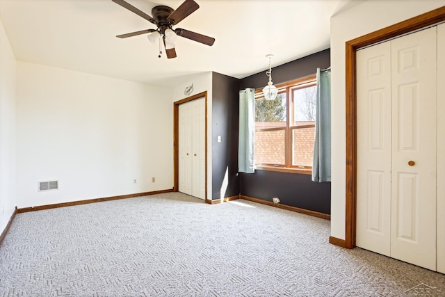 unfurnished bedroom featuring visible vents, ceiling fan, carpet, and baseboards