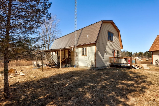 back of property featuring a gambrel roof, metal roof, and a deck