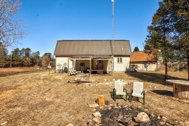 rear view of house featuring an outbuilding and metal roof